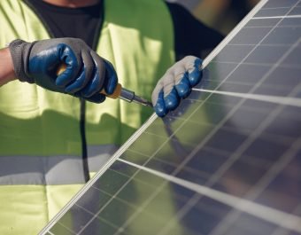 Engineer in a white helmet. Man near solar panel.